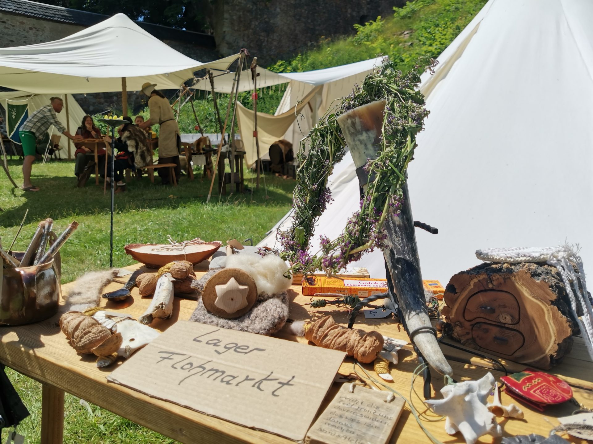 Tisch mit mittelalterlichen Gegenständen und einem Schild mit der Aufschrift Lager Flohmarkt