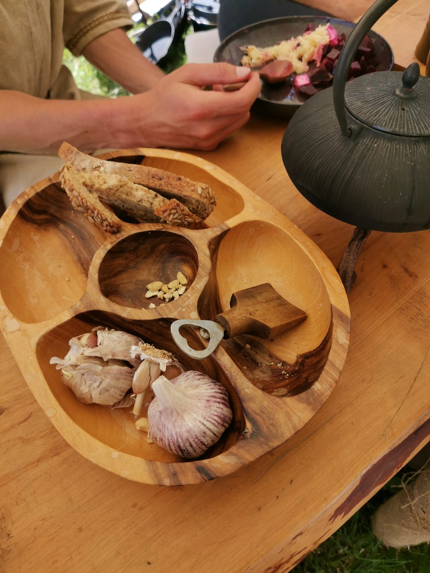 Holzteller mit Knoblauch, Brot und Kräutern auf einem Lagertisch, mittelalterliche Küche